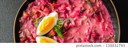 Delicious cold beet soup is garnished with boiled eggs and fresh herbs in a simple black bowl. The vibrant colors and textures create an inviting dish perfect for summer meals, banner Delicious cold beet soup is garnished with boiled eggs and fresh herbs in a simple black bowl. The vibrant colors and textures create an inviting dish perfect for summer meals, banner 138832793