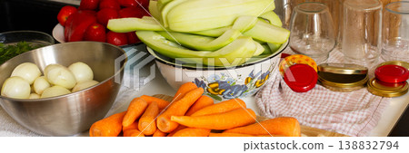 Fresh vegetables are arranged on a kitchen countertop for making squash caviar. Squash, carrots, tomatoes, and ingredients are prepared for winter canning, banner 138832794