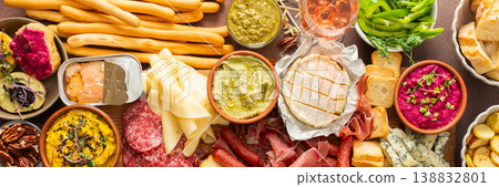 This festive spread features an array of cheese, cured meats, hummus, nuts, and fresh vegetables. Perfect for sharing at a casual get-together or celebration with friends, banner This festive spread features an array of cheese, cured meats, hummus, nuts, and fresh vegetables. Perfect for sharing at a casual get-together or celebration with friends, banner 138832801