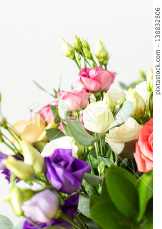 A beautiful bouquet of vibrant roses, eucalyptus, and delicate eustoma in white, pink, and purple hues, perfect for a summer anniversary or birthday celebration 138832806