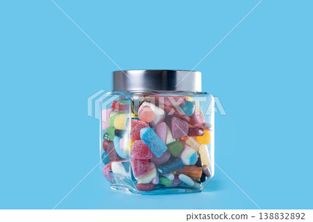 Colorful assorted gummy candies in glass jar on blue background Colorful assorted gummy candies in glass jar on blue background 138832892