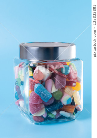 Colorful assorted gummy candies in glass jar on blue background 138832893