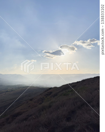 Sun shining over hills on a hazy day in the countryside 138833102