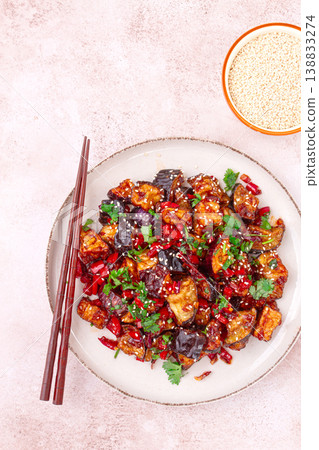 fried eggplant, Chinese style, in sweet and sour sauce, with pepper and sesame seeds. on a white plate, fried eggplant, Chinese style, in sweet and sour sauce, with pepper and sesame seeds. on a white plate, 138833274