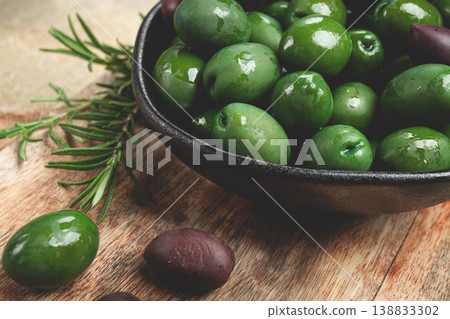 Chalkidiki olives, classic Greek green olives, in a bowl on a cutting board, top view, without people, 138833302