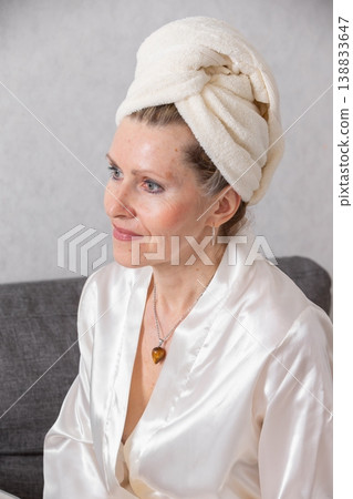 Woman with towel wrap on head relaxing in silk robe at home during afternoon Woman with towel wrap on head relaxing in silk robe at home during afternoon 138833647