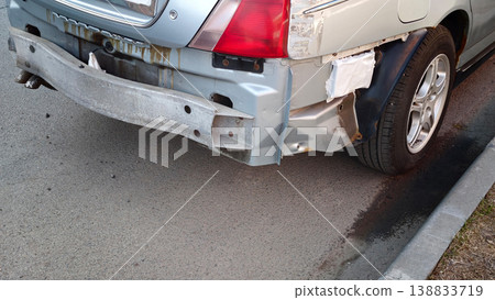 Car with damaged rear bumper parked near a sidewalk in an urban area during daylight Car with damaged rear bumper parked near a sidewalk in an urban area during daylight 138833719