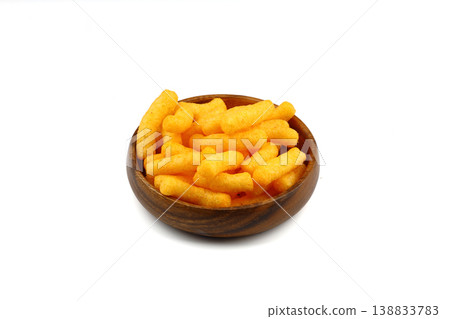 Cheese flavored corn puffs in wooden bowl isolated on white background, crunchy savory snack food Cheese flavored corn puffs in wooden bowl isolated on white background, crunchy savory snack food 138833783