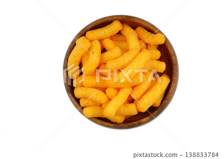 Cheese flavored corn puffs in wooden bowl isolated on white background, crunchy savory snack food Cheese flavored corn puffs in wooden bowl isolated on white background, crunchy savory snack food 138833784