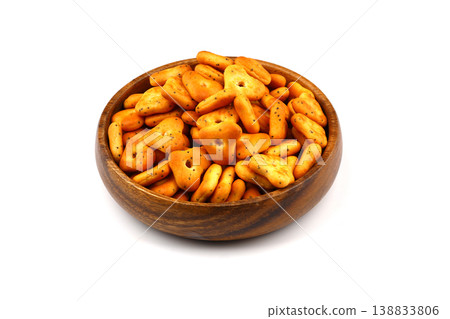 Crispy spicy triangle crackers in rustic wooden bowl isolated on white background, savory snack Crispy spicy triangle crackers in rustic wooden bowl isolated on white background, savory snack 138833806