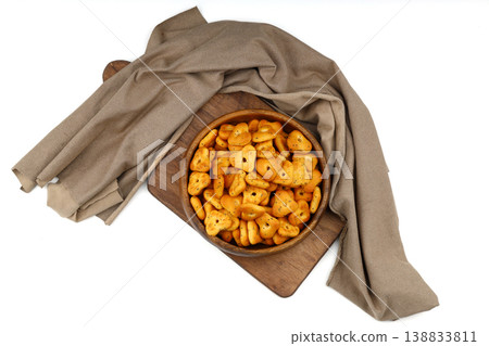 Crispy spicy triangle crackers in rustic wooden bowl isolated on white background, savory snack Crispy spicy triangle crackers in rustic wooden bowl isolated on white background, savory snack 138833811
