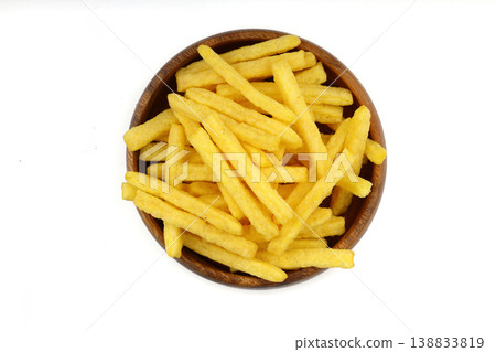 Steak flavored corn chips sticks in wooden bowl isolated on white background, crunchy savory snack Steak flavored corn chips sticks in wooden bowl isolated on white background, crunchy savory snack 138833819