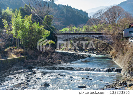 The arch bridge and clear stream of the Hakii River in Minobu Town, Yamanashi Prefecture: A winter landscape of rural mountains. The arch bridge and clear stream of the Hakii River in Minobu Town, Yamanashi Prefecture: A winter landscape of rural mountains. 138833895