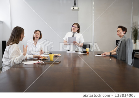 Women working and having conversation during business meeting at large conference table in office. Conversation, working, conference, meeting, business, women. 138834003