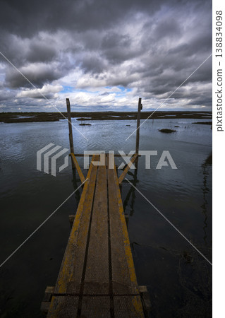 Rusty jetty out to salt marsh in Essex 138834098