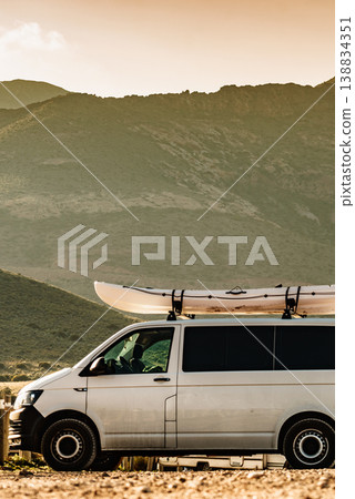 Canoe on roof top of car against mountain Canoe on roof top of car against mountain 138834351