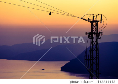 High voltage towers on coast at sunset 138834418