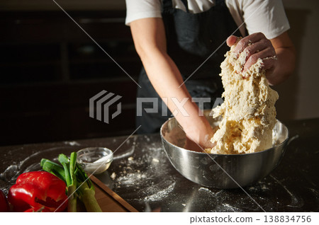 Woman kneading fresh dough in bowl during cooking process Woman kneading fresh dough in bowl during cooking process 138834756