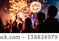 Crowd of people watching colorful fireworks display at night during a festive celebration with bright lights illuminating the sky 138834979