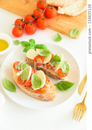 Bruschetta toasts with mozzarella, cherry tomato and basil leaves Bruschetta toasts with mozzarella, cherry tomato and basil leaves 138835126