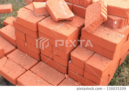 Large pile of red ceramic bricks stacked on a wooden pallet at a construction site. High-quality clay masonry Large pile of red ceramic bricks stacked on a wooden pallet at a construction site. High-quality clay masonry 138835209
