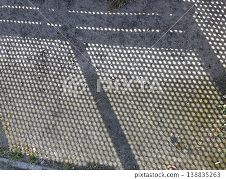 Mesh Shadows Create Patterns on Concrete Ground During Afternoon Light in a City Park Mesh Shadows Create Patterns on Concrete Ground During Afternoon Light in a City Park 138835263
