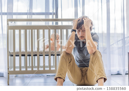 Tired father sitting by baby crib at home watching sleeping infant. Exhausted dad caring for newborn at night. Parenting fatigue, childcare responsibility, love and real family life concept 138835560