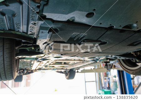 在修理廠對升起的汽車進行底盤檢查 在修理廠對升起的汽車進行底盤檢查 138835620