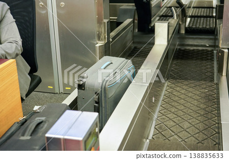Checked in bags and luggage on transport belt of airport check-in desk Checked in bags and luggage on transport belt of airport check-in desk 138835633