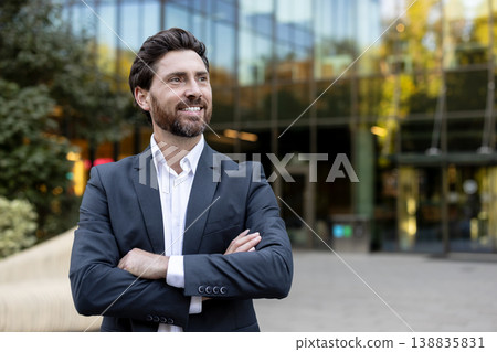 Confident businessman standing outdoors, looking away and smiling, portraying success, leadership, and a positive future with an urban office building background Confident businessman standing outdoors, looking away and smiling, portraying success, leadership, and a positive future with an urban office building background 138835831