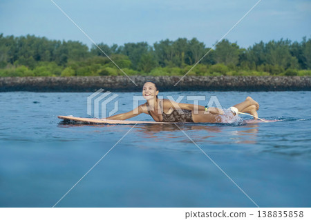 Tranquil Maiden Attentively Paddling On Surfboard Amidst Verdant Beach Landscape Tranquil Maiden Attentively Paddling On Surfboard Amidst Verdant Beach Landscape 138835858
