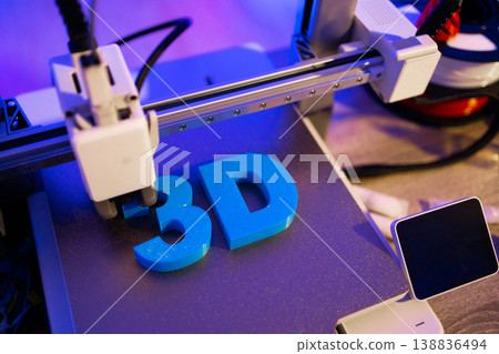 A modern 3D printer is actively creating the letters '3D' in bright blue plastic on its build plate A modern 3D printer is actively creating the letters '3D' in bright blue plastic on its build plate 138836494