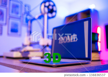 A laptop displaying the word HOME sits on a desk next to a 3D printer, illuminated by vibrant neon lights A laptop displaying the word HOME sits on a desk next to a 3D printer, illuminated by vibrant neon lights 138836537