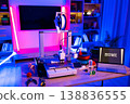 A 3D printer is actively creating the word HOME in white letters on its build plate, surrounded by filament spools and tools, illuminated by neon lights 138836555