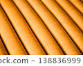 Fragment of orange satin smooth leather popular in Italian designer furniture. Natural material with elegant lines and refined texture. Premium upholstery surface ideal for luxury interior backgrounds 138836999