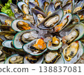 High angle view of cooked green mussels on shells arranged in a circle on ice. Seafood platter on display at a market. Healthy mediterranean food. 138837081
