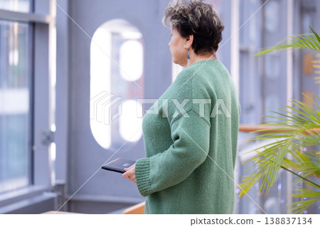 Mature woman working on laptop in shopping mall interior Mature woman working on laptop in shopping mall interior 138837134