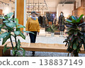 Mature woman walking in modern shopping mall near clothing store window 138837149