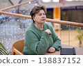 Mature woman working on laptop in shopping mall interior 138837152