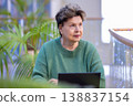 Mature woman working on laptop in shopping mall interior 138837154