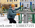 Senior woman exercising on outdoor fitness machine in winter 138837155