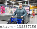 Senior woman shopping in modern supermarket during winter 138837156