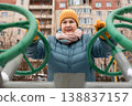 Senior woman exercising on outdoor fitness machine in winter 138837157