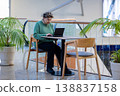 Mature woman working on laptop in shopping mall interior 138837158