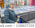 Senior woman shopping in modern supermarket during winter 138837159