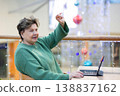 Mature woman working on laptop in shopping mall interior 138837162