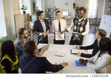 Mixed team of professionals in office meeting with presenting and project planning Mixed team of professionals in office meeting with presenting and project planning 138838190
