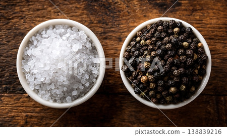 Salt and pepper in bowls on wood 138839216