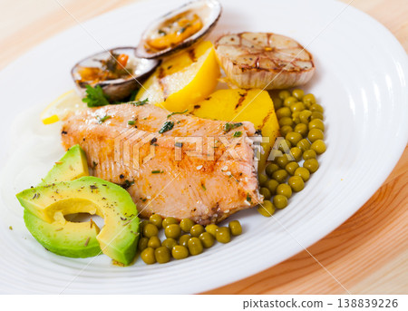 Baked trout fillet with vegetables and dog cockles 138839226
