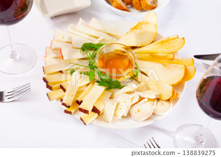 Cheese plate served with honey on wooden table Cheese plate served with honey on wooden table 138839275